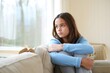 © Vision Link - Sad Teenager Girl Sitting on Couch Looking Out Window