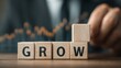© Kelik - Wooden blocks spell GROW with upward graph with symbolizing business expansion.