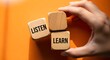 © graphiczone872 - Hand holding wooden blocks with listen and learn text on orange background, education concept