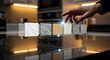 © Visual Embun - Close-up of a hand touching a selection of countertop material samples, showcasing different textures and colors for interior design.