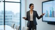 © Rusdan - Confident businesswoman presenting financial data on a large screen in a modern office.