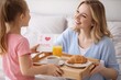 © Alla Bondaruk - Mother’s Day advertising, family marketing campaigns, greeting cards, parenting blogs, lifestyle promotion. Happy Mother’s Day Morning – Child Giving Breakfast and Love Card to Mom at Home