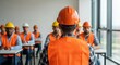 © Olga Ко - Construction workers in hard hats and reflective vests attending a workplace safety training seminar in a bright classroom