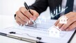 © Zoe - Financial planning and real estate investment analysis,hand with pen reviewing market chart and house icons for property growth and mortgage strategy