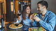 © Dragana Gordic - Smiling Couple Laughing While Sharing Pizza And Red Wine At A Cozy Restaurant Date Night