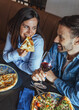 © Dragana Gordic - Happy Couple Sharing Pizza and Red Wine on a Cozy Date at a Casual Restaurant