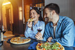 © Dragana Gordic - Happy Couple Enjoying Pizza and Red Wine During Casual Date Night at Cozy Restaurant