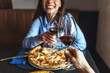 © Dragana Gordic - Couple Toasting With Red Wine Over Pizza During Cozy Romantic Dinner Date At A Restaurant