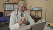 © Krakenimages.com - Man doctor in white coat with stethoscope holds prescription bottle at desk in clinic building while examining the label; concern medical decision.
