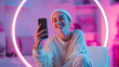 © Lumi Stock Studio - ultra realistic confident social media influencer smiling with smartphone, stylish woman in beanie with neon ring light background, trendy content creator holding phone in vibrant pink and blue studio