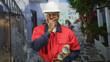 © Krakenimages.com - Man construction worker in white hard hat holding rolled blueprints covers mouth with hand in narrow street; surprise.