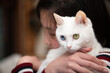 © hakase420 - 飼い主に抱かれている白い猫