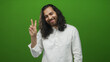 © Krakenimages.com - Young man with long hair and white shirt showing peace sign with hand in green studio; playful optimism.