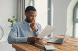 © Daniel - Concentrated African American manager reading letter, paper handout, analyzing company statistics, thinking about financial risks, comparing results. Thoughtful black worker considering business offer