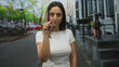 © Krakenimages.com - Woman pointing index finger to camera on street, white tshirt with visible hand and forearm gesture near face conveying emphasis; confidence.