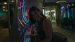 © Krakenimages.com - Woman brunette sitting with hand on slot machine control panel, smiling broadly and looking up toward the screen in a casino building; luck excitement.