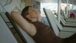 © Krakenimages.com - Woman reclining on deck chair with arms behind head and armpit visible in a building; quiet calm rest.