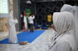 © Aliioss - Muslim women in white hijabs attending a formal religious ceremony or event in Indonesia.