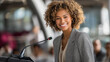 © Nataliya - Confident unrecognizable young African female speaker presenting to an audience in a conference setting, public speaking, female leadership, professional event concept, with copy space