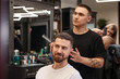 © New Africa - Barber showing to client his new haircut indoors. Space for text
