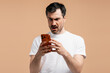 © Maria Vitkovska - Man reacting to shocking bad news on phone, experiencing anger and frustration