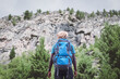 © arrowsmith2 - Adventurous African Hiker with Backpack Looking Up at Majestic Mountain Peaks