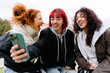 © ADDICTIVE STOCK - Friends taking a joyful selfie in urban setting