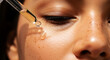 © syful - Close up of dropper applying golden serum drop to woman's freckled cheek liquid skin