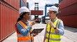 © Vasiliy - Logistics managers discussing cargo operations in a shipping container yard. Diverse male and female port workers in safety gear using a tablet at a freight transport terminal