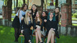 © Довидович Михаил - Happy students having fun together, sitting on a bench in the schoolyard, capturing special moments of their friendship