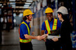 © ultramansk - Confident female executive and logistics team communicating in modern storage facility. Commercial business workers using digital tablet for distribution operations.