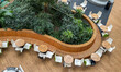© reddish - High angle view of modern indoor cafe with circular wooden bench and lush green plants