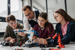 © Halfpoint - High school students working on robotics project with their teacher.