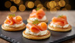 © Jim - Smoked salmon appetizers arranged on slate. Small cornbread cakes topped with cream cheese, salmon, and dill. Cozy bokeh lights add festive atmosphere for parties or events. Gourmet Party Appetizers