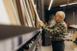 © Roman - Senior man choosing wood planks at hardware store