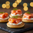 © Jim - Smoked salmon appetizers arranged on slate. Small cornbread cakes topped with cream cheese, salmon, and dill. Cozy bokeh lights add festive atmosphere for parties or events. Gourmet Party Appetizers