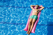 © Westend61 - Shirtless handsome young man with hands behind head relaxing on airbed in swimming pool