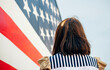 © Westend61 - USA, back view of woman in front of Stars And Stripes