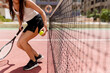 © Westend61 - Female tennis player holding racket and ball while standing by net in court