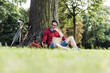© Westend61 - Man using laptop and cell phone in park