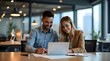 © Nataliya - Man and woman sitting at table with laptop, professional business team collaborating on digital project in modern workspace for career success concept