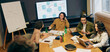 © Daria - Group Strategizing Collaboratively, Collaborative Team Reviewing Project Timelines And Presentation Charts