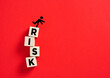 © Cagkan - Person icon falling from RISK blocks on red background visualizing business danger, challenge, failure, and unstable financial strategy