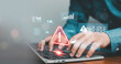 © ภัทรชัย รัตนชัยวงค์ - Hands typing on laptop with glowing warning alert and virtual data dashboard interface. Concept of cybersecurity risk, system error detection, data protection, online security monitoring technology