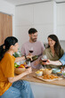 © Westend61 - Friends enjoying dinner and wine together at home kitchen