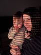 © phpetrunina14 - Mother and toddler in warm sunlight with window blind shadows Portrait
