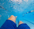 © phpetrunina14 - Underwater pov of swimmer legs in blue pool Copy Space