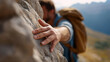 © Denis Yevtekhov - Faceless backpacker extending a hand down from a rocky ledge to help another climber ascend, defocused mountain landscape behind, mountain helping hand, trekking support, friendship climbing,