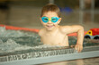 © Tomsickova - Child, taking swimming lessons in a group of children in indoor pool
