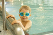 © Tomsickova - Child, taking swimming lessons in a group of children in indoor pool